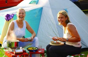 Campingplatz Silbermöwe Aussenfoto Mädchen beim Essen vor ihrem Zelt mit Kocher und Pfanne