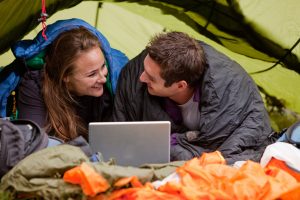 Campingplatz Ausstattung: Paar mit Laptop im Zelt mit WLAN