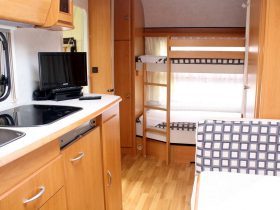 Campingplatz St. Peter-Ording - Mietwohnwagen mit Küche, Fernseher, Mittelsitzgruppe und Etagenbett